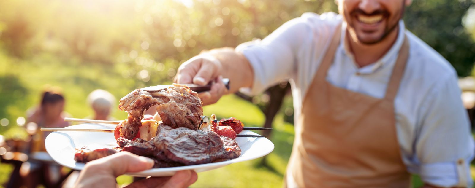Family,Having,A,Barbecue,In,The,Garden,,Eating,And,Having