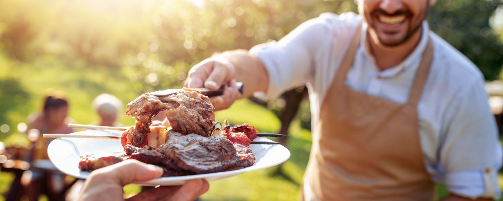 Family,Having,A,Barbecue,In,The,Garden,,Eating,And,Having
