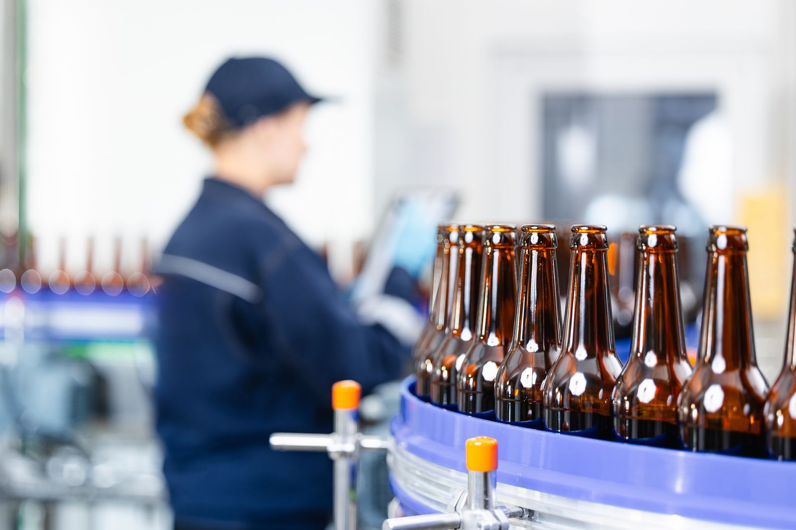 Beer production line in factory with focus on bottling process, worker control process